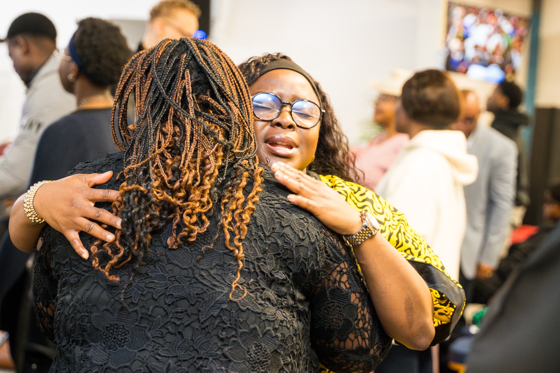 Two women warmly greeting one another at Dunamis Milton Keynes